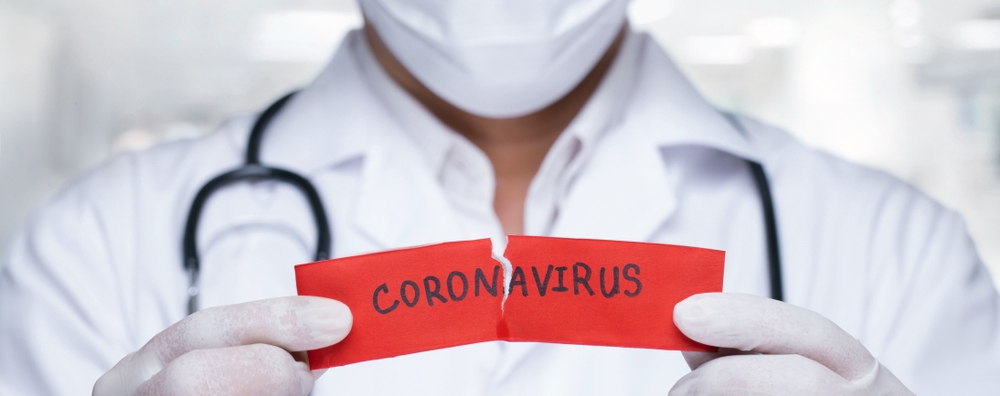 Man ripping a coronavirus word in half