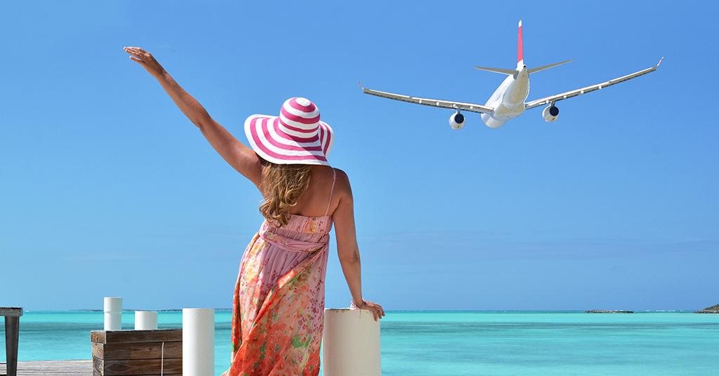 A woman waves off a plane on a beach