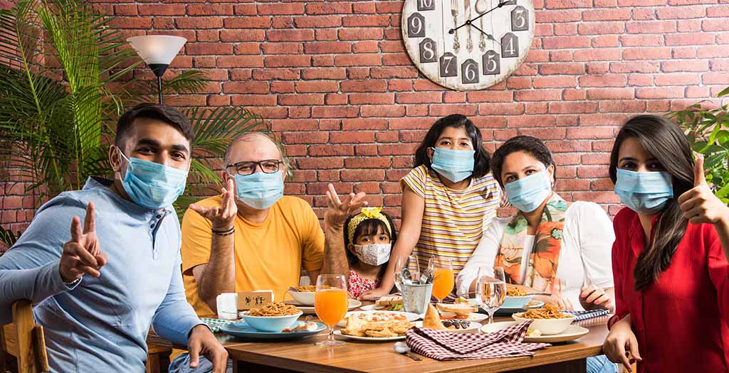 happy family eating with masks