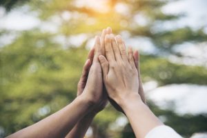 Four hands doing a group High Five