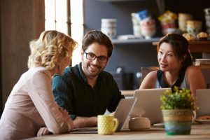 Informal business meeting between three people in a cafe