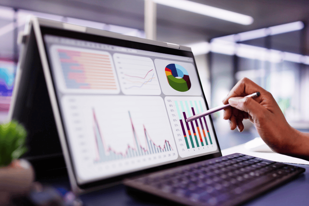 Pointing at data on a laptop. 